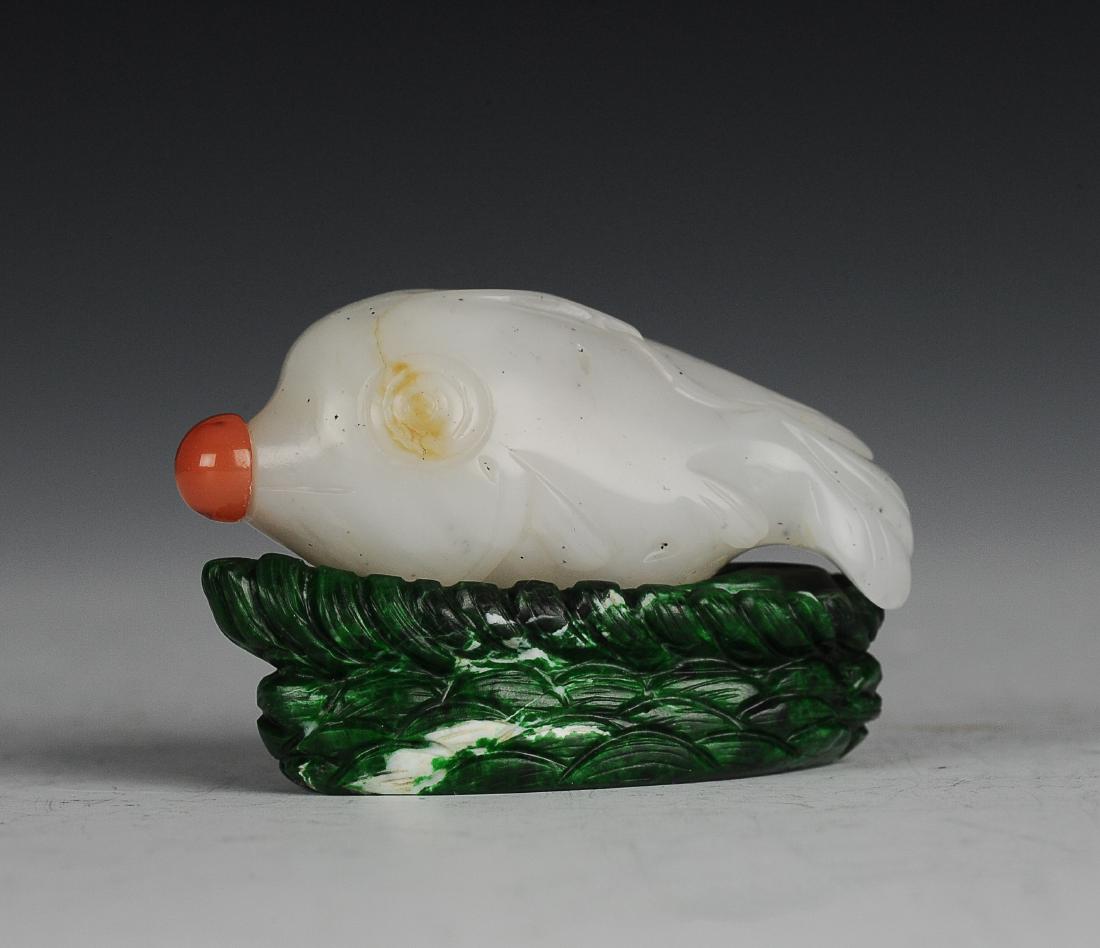 Fish Form White Jade Snuff Bottle, 19th Century: White jade snuff bottle carved into the form of a fish from the 19th century. The snuff bottle is intricately carved into a fish with the stopper as a mouth. The stopper includes a spoon. The snuff bo