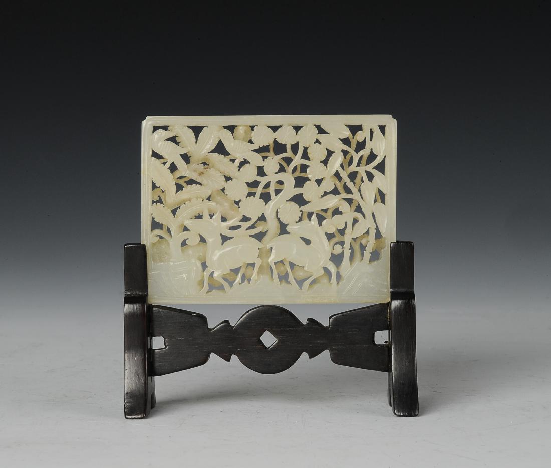 White Jade Openwork Plaque with Stand, Ming Dynasty: Rectangular white jade plaque carved in openwork from the Ming dynasty. Plaque is carved with deer and birds within a forest. It has a carved wooden stand. Dimensions are 2 5/8 inches wide by 2 inches