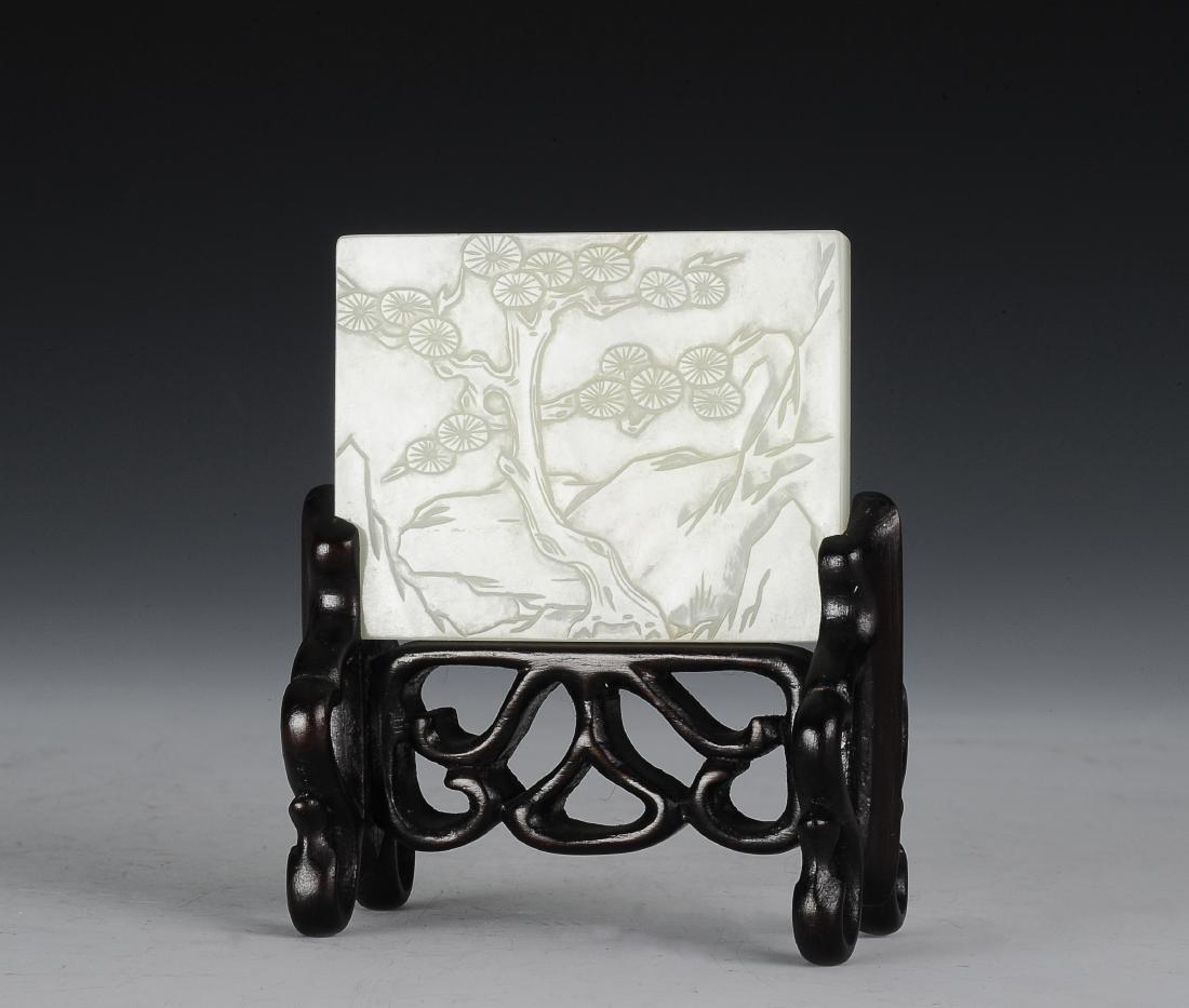 White Jade Belt Buckle with Stand, Ming Dynasty: Rectangular, white jade belt buckle from the Ming dynasty. The white jade buckle is carved on one side with a pine tree in a mountainous landscape. The back side is carved with two buttons. It has a c