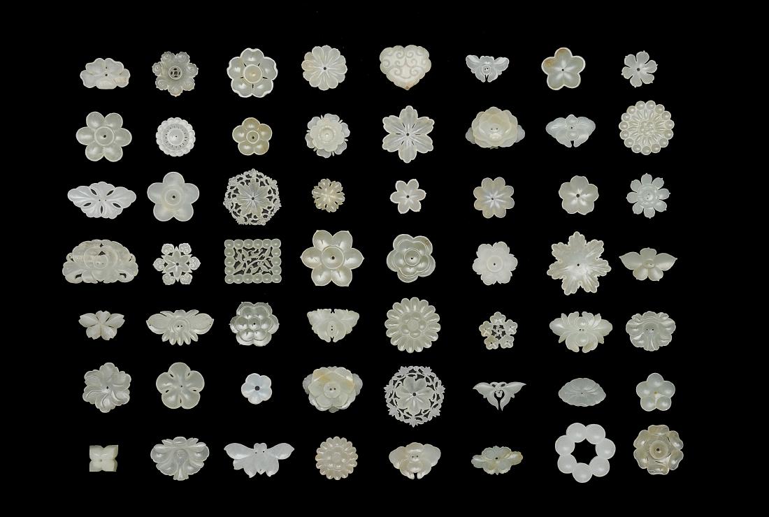 56 Jade Floral Carvings, Ming Dynasty: Group of 56 jade carvings in a wooden box from the Ming dynasty. This group of 56 individual white jade carvings mainly consists of flowers and insects. Most of the carvings can serve as buttons. Dime