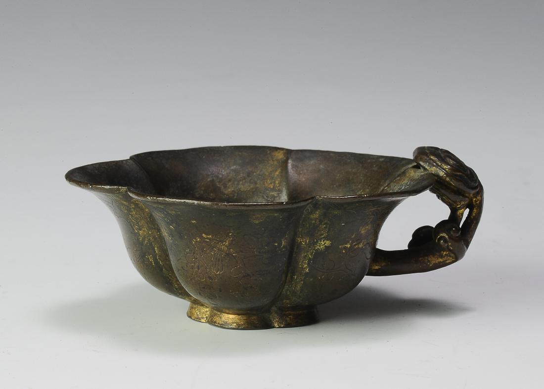 Gilt Bronze Flower Cup, Ming Dynasty: Gilt bronze flower cup from the Ming dynasty. Flower form cup with a lingzhi handle. The exterior of the cup is finely etched with flowers and branches. Dimensions are 3 5/8 inches wide by 1 3/8 inche