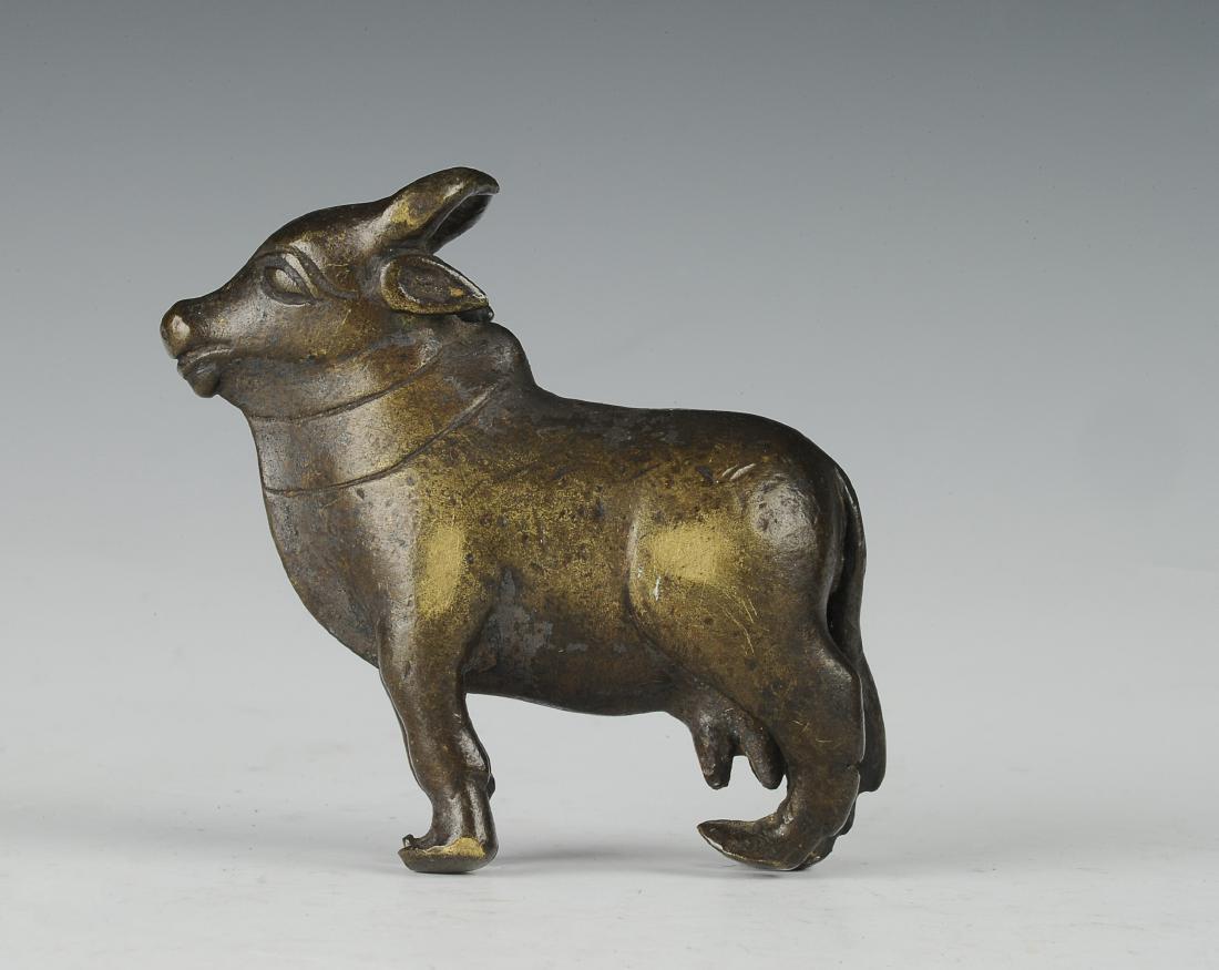 Bronze Cow Paperweight, Ming Dynasty: Small bronze cow paperweight from the Ming dynasty. The cow has horns that curve back, a large dewlap, and a prominent hump at the shoulder. Dimensions are 2 3/4 inches wide by 2 1/2 inches high. All 