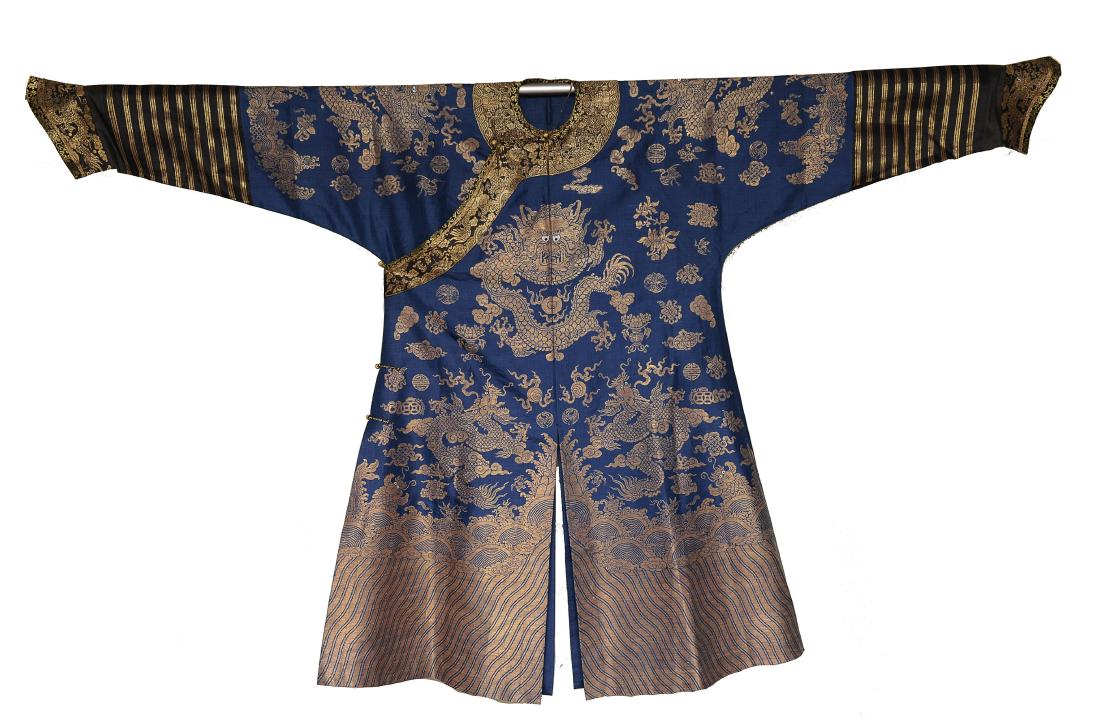 Blue Ground Dragon Robe, 19th Century: Blue ground silk robe with gold toned embroidery from the 19th century. The robe is embroidered with 5-clawed dragons, flowers, and Buddhist symbols. The bottom of the robe is embroidered with a wave 