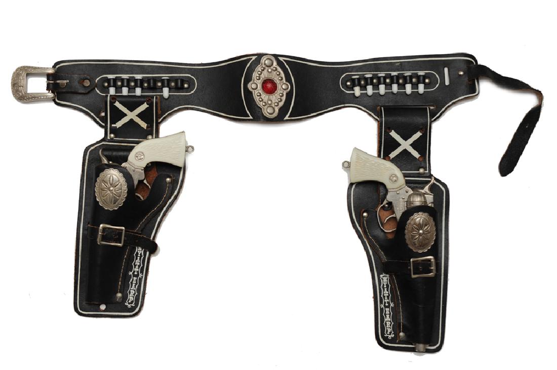 Wyatt Earp Belt, Holster, & Cap Guns: A leather belt with holsters marked "Wyatt Earp" and 2 cap guns, one marked "Wyatt Earp Buntline Special" and one marked "Wyatt Earp". Dimensions are: 4 3/4" tall X 11" wide. All measurements are ap