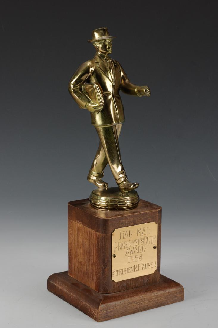 Har-Mac President's Club Salesman Trophy, 1954: A metallic trophy on a wood base acknowledging the Har-Mac President's Club Award for 1954. Dimensions are: 13" tall X 5" wide. All measurements are approximate. It is in Fine Condition, the metal has