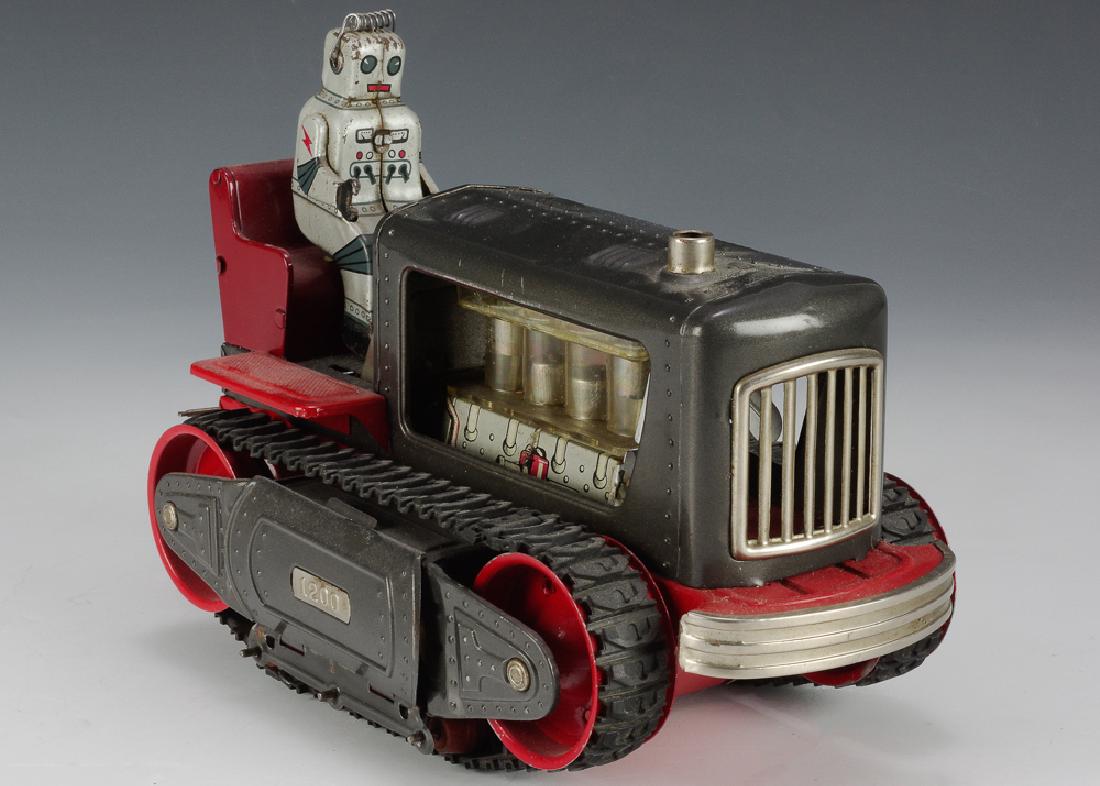 Battery Operated Robot Tractor by Nomura: Battery operated toy tractor with robot. Tractor is red and grey and has rubber tracks. Dimensions are: 9 3/4" long X 4 7/8" wide. All measurements are approximate. Very good Condition overall with so