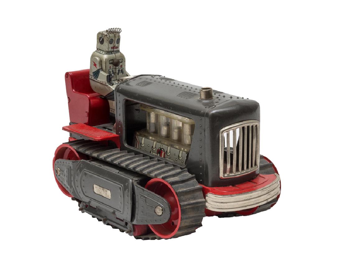 Battery-Operated Robot Tractor by Nomura: Battery operated toy tractor with robot. Tractor is red and grey and has rubber tracks. Dimensions are: 9 3/4" long X 4 7/8" wide. All measurements are approximate. Some wear to the paint, very good. 
