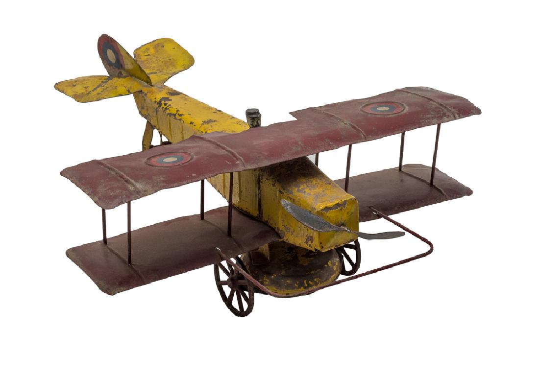 Clockwork Biplane by Kingsbury: Pressed steel Kingsbury biplane with original yellow and red paint. Includes pilot figurine. Plane operates by a windup clockwork mechanism. Dimensions are: 16" long. All measurements are approximate.
