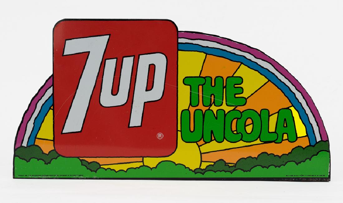 7-Up 'The UnCola' Sign by Peter Max: Metal 7-Up sign with sunrise scene and "The Uncola" slogan. Signed by designed by Peter Max Sign is marked 'No. 14, Made in U.S.A' by the Stout Sign Co., St. Louis, MO.' Dimensions are: 23 3/4" wide