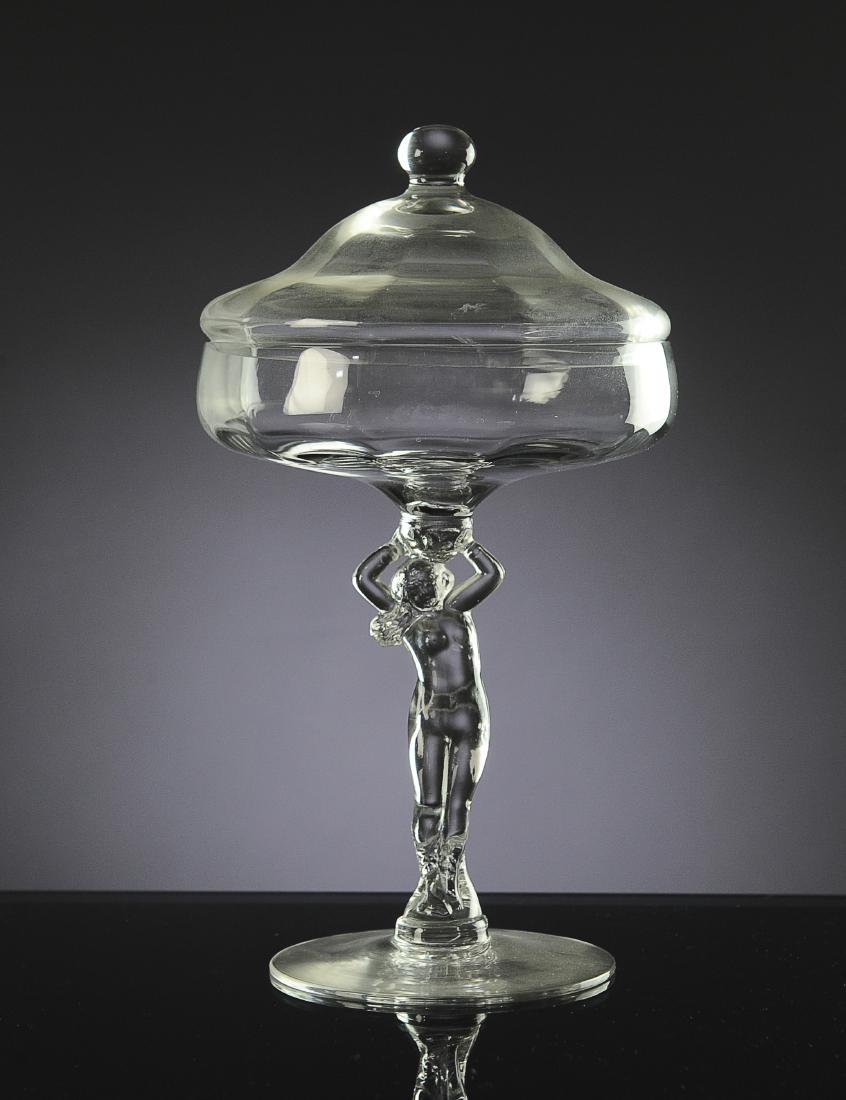 Cambridge Glass Nude Stem Covered Candy Dish: Crystal clear with shaped lid. Dimensions are: 9 1/2" tall, 5 1/2" dia. All measurements are approximate. Condition: No noted damage. Excellent. Provenance: The lifetime collection of Linda Racey.