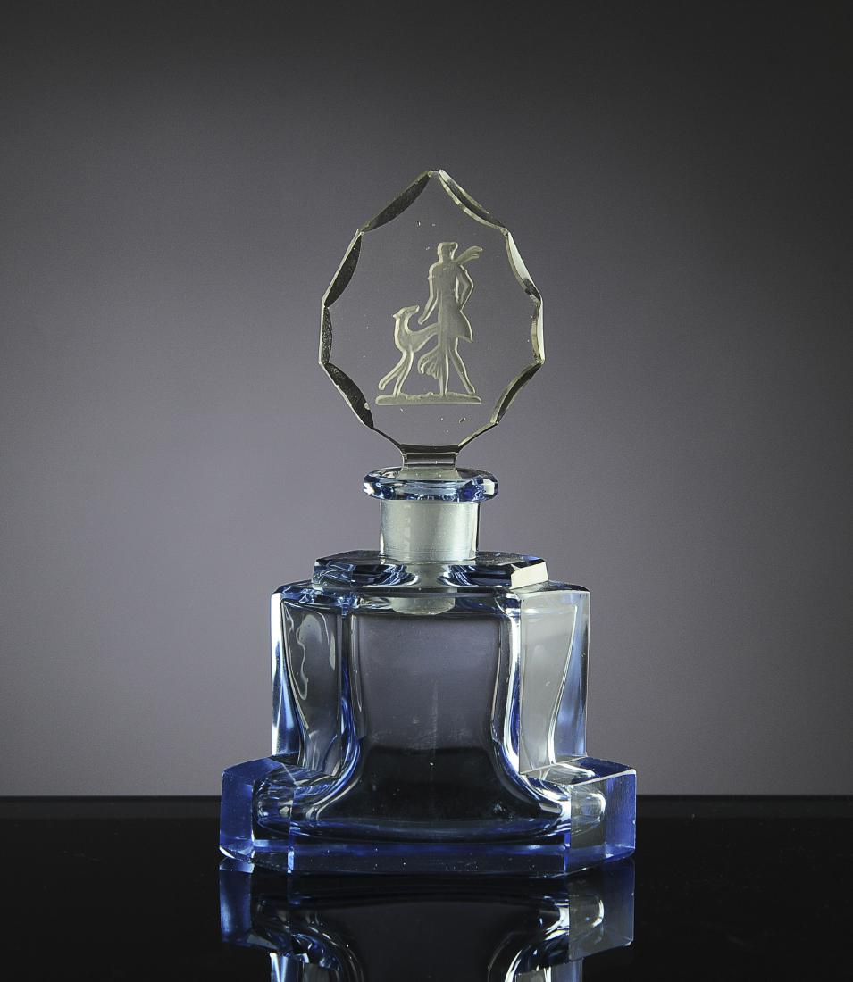 Art Deco Czech Glass Blue Perfume Bottle: Clear intaglio stopper with a woman and greyhound. Dimensions are: 4 13/16" tall, 3 7/8" wide. All measurements are approximate. Condition: Small fleck to edge of stopper. Fine. Provenance: The lifeti