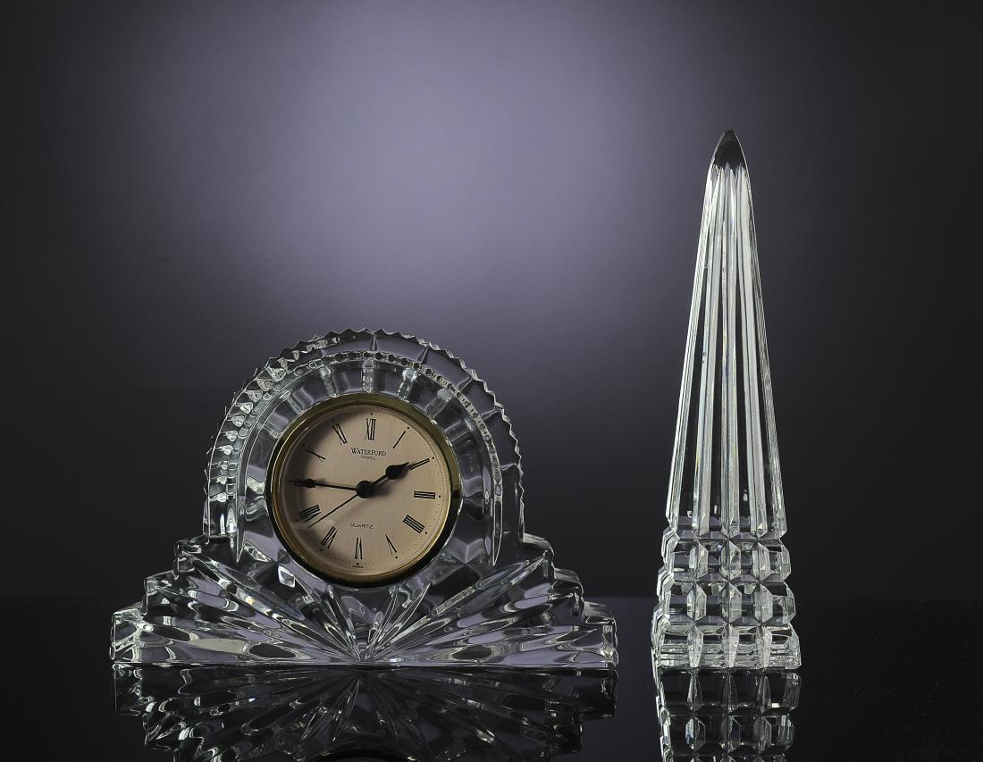 Two Pieces of Waterford Crystal: Two signed pieces of Waterford crystal. One is a desk clock and the other is an obelisk. Dimensions are: clock 7 1/8" wide, 1 7/8" deep, 4 5/8" tall. All measurements are approximate. Condition: No no