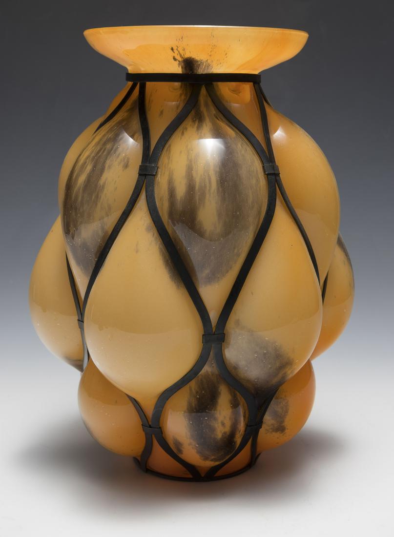 Orange Kralik Glass Vase with Metal Frame: An orange and brown Czech glass vase in the Kralik style, blown inside a metal frame. Dimensions: 10 1/2" tall. All measurements are approximate. Condition: No noted damage. Excellent. Provenance: The