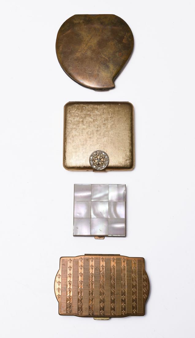 Four Gold Metal Compact Mirrors: Four gold metal compact mirrors. One is marked 'Avon' and has a rhinestone closure, one is marked 'Elgin American', and one is marked 'Van-Ace'. The fourth is unmarked and has a mother-of-pearl top. D
