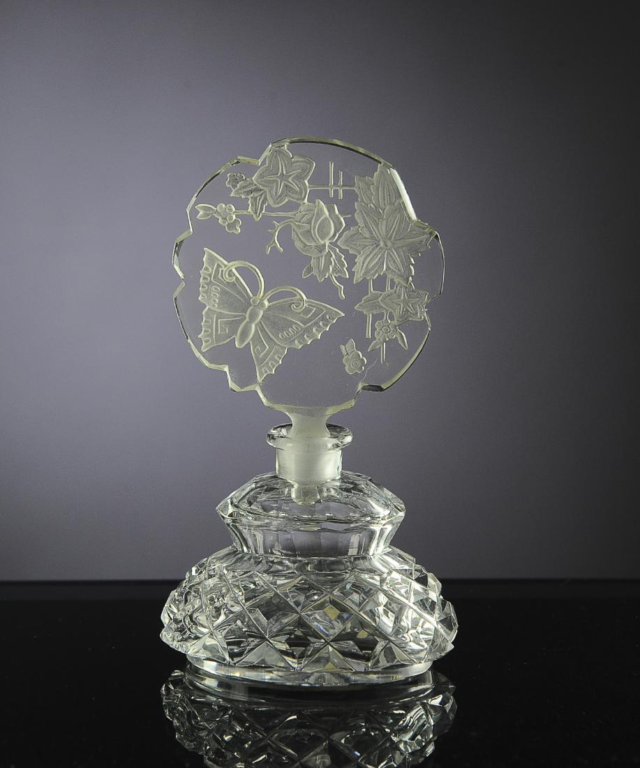 Clear Czech Perfume with Morlee Paper Label: Marked 'Made in Czechoslovakia' on bottom. Intaglio stopper depicts a butterfly with flowers. Dimensions are: 5 1/4" tall. All measurements are approximate. Condition: Edge chip to stopper at one flow