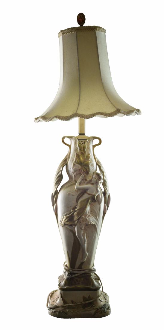 An Amphora Art Nouveau Table Lamp: Amphora pottery on matching carved wood base. Dimensions are: 39" tall, base 8" wide. (Lamp body 23 1/4" tall). All measurements are approximate. Condition: Light aging to pottery, base has paint wear