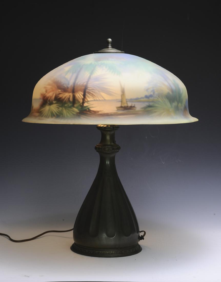 Reverse Painted Pairpoint Lamp and Palm Shade: Beautiful shade with the beach, palm trees, and a sailboat. Base no. D3059 with original paper label on bottom. Both base and shade signed Pairpoint. Dimensions are: 23 1/2" tall. Shade 19 5/8" dia wi