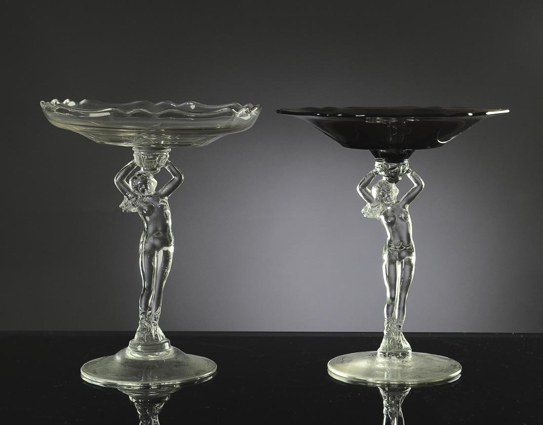 Two Cambridge Glass Nude Stem Compotes: Two Cambridge glass nude stem compote dishes, one in Crystal and the other in Peach-Blo. Dimensions are: 8" tall. All measurements are approximate. Condition: No noted damage. Excellent. Provenance: T