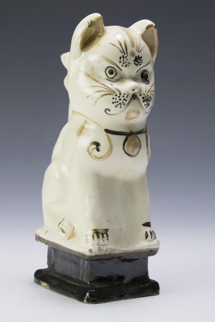 19th Century Glazed Earthenware Cat: Probably English, seated cat on a pedestal. Dimensions are: 8" tall, 3 1/2" long. All measurements are approximate. Condition: Some age cracks. Very Good
