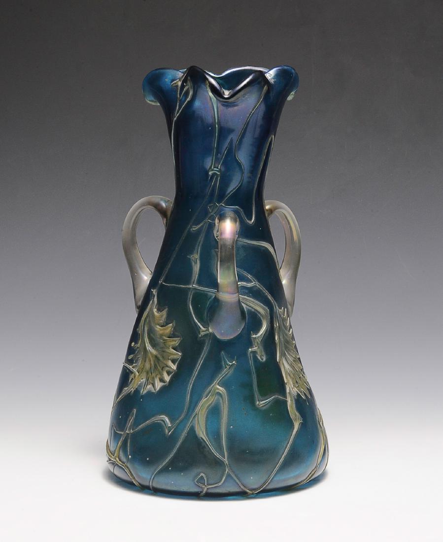 Blue Pallme Koenig Vase: Iridescent blue vase with applied handles and pinched rim. Dimensions are: 11" tall, 6" dia. at base. All measurements are approximate. Condition: Light scratch to the bottom of the vase. Excellent.