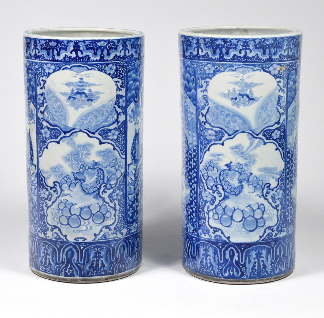 Pair of Chinese Blue & White Umbrella Stands: A pair of blue and white Chinese porcelain umbrella stands decorated with auspicious symbols. Dimensions are: 24 1/2 inches tall X 12 inches wide. All measurements are approximate. Condition: Both hav
