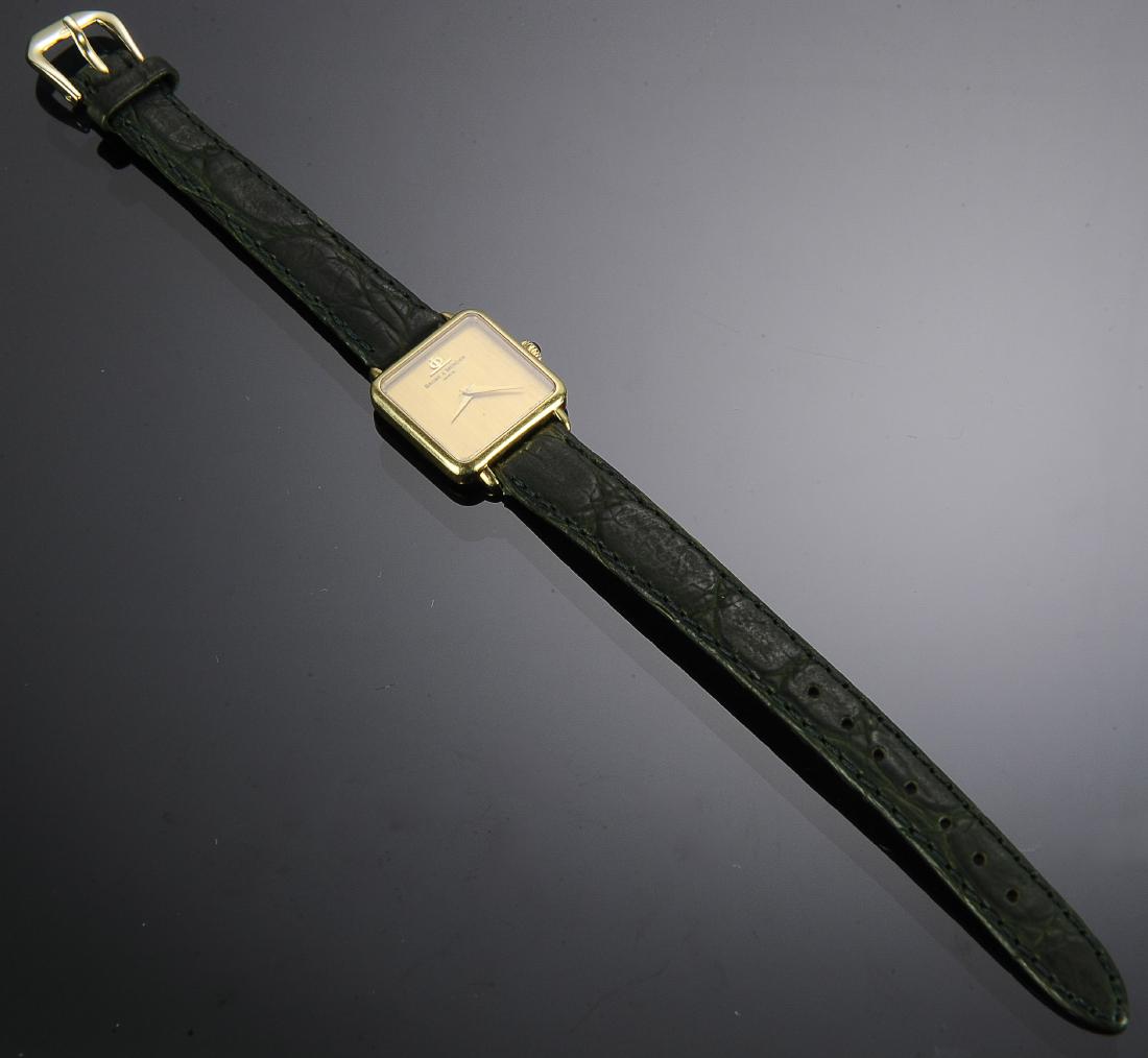 14K Gold Baume and Mercier Ladies Watch: 14K Gold Baume and Mercier Ladies Watch: 14K gold 17 jewel Baume & Mercier watch with green leather Kreisler watch strap. Brushed gold watch face and crown is embellished with blue glass cabochon. Mov