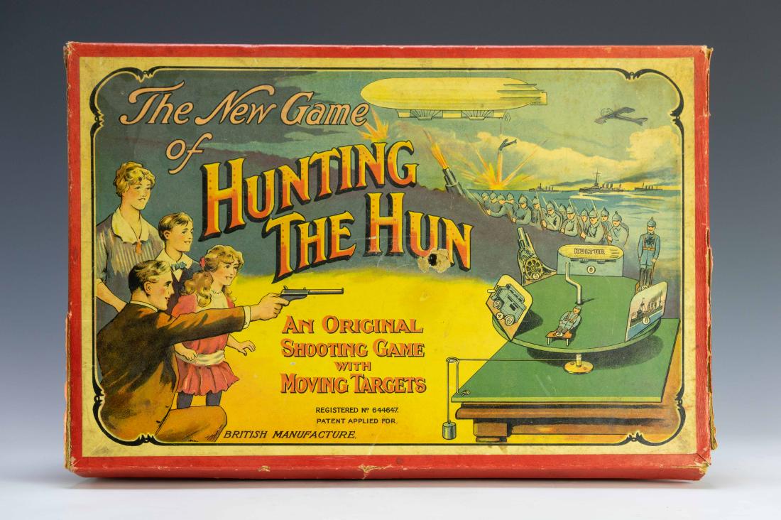 Hunting The Hun WWI Target Game: Rare example of a British game from WWI called "Hunting the Hun" with a weight mechanical target wheel with six German targets, gun, & ammo. Dimensions are: target - 10" dia, box - 16 1/2" long X 10 1