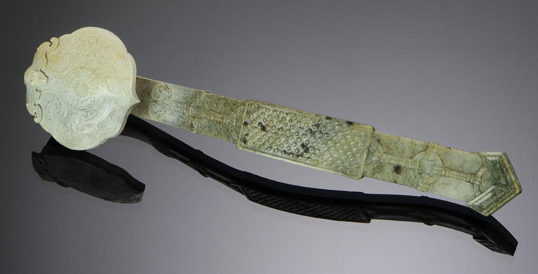 Chinese Chicken Bone Jade Ruyi Wand, 18th C.: Chinese chicken bone jade ruyi wand dating from the 18th century. The head is carved with a bi disc surrounded by stylized chilong and ruyi tracery with a bat, and the handle is carved with a plaque c