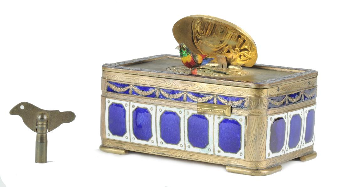 Cloisonne Music Box, 18th-19th Century: This elegant blue and white enameled music box of European make has a garland pattern along the upper border. The lid is painted with a pastoral landscape including people and has a glass cover. When 