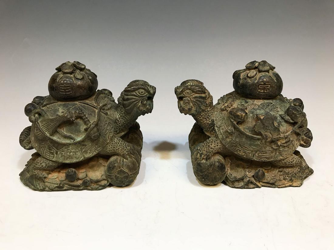Pair Chinese Style Bronze Turtles: Pair of bronze world turtles in the Chinese style. Turtles each carry a cinched bag, as well as other items like fish and musical instruments. Design includes various Chinese characters. Dimensions ar