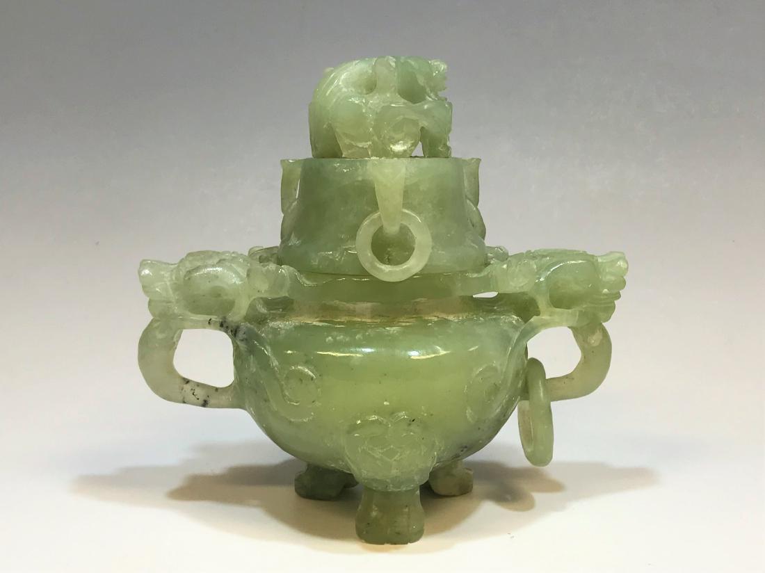 Green Jadeite Censer, Dragon Motif: A Chinese jadeite tripod censer with a lid carved with a dragon finial and 3 attached rings. The 3 legs are carved with taotie masks and there are 2 dragon handles on the body of the censer, 1 with an