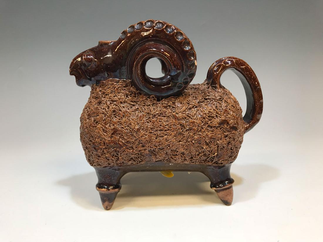Ceramic Redware Ram Animal Art Pottery Pitcher: Ceramic redware ram form animal pitcher. impressed maker's mark on base. Dimensions are: 8" tall X 9" long X 3 1/2" wide. All measurements are approximate. Condition: Scattered chipping, the largest m