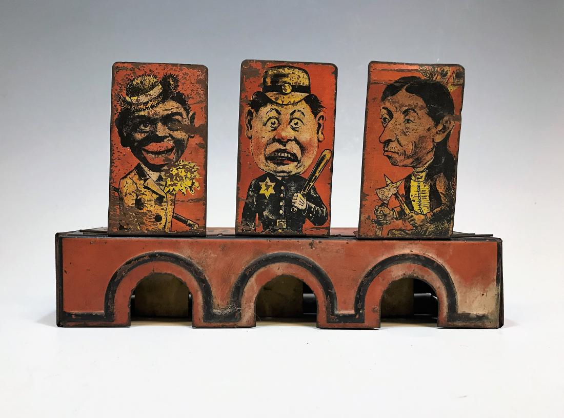 Tin Litho Roll "M" Game by A.J.J. Co.: Tin ball game dates to circa 1915 with a Black Dandy, Keystone style cop and a Native American Indian brave. Dimensions are: with targets down - 9 3/8" wide X 4" deep X 1 7/8" tall. All measurements a