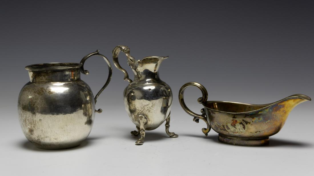 (3) British Sterling Cream Jugs / Pitchers / Sauce: (3) British Sterling Cream Jugs / Pitchers / Sauce: a) London, 1882, pitcher with three hoof feet supporting an urn form body with single scrolled handle. Dimensions are: 4" tall, weight: 97.3g, 3.12o
