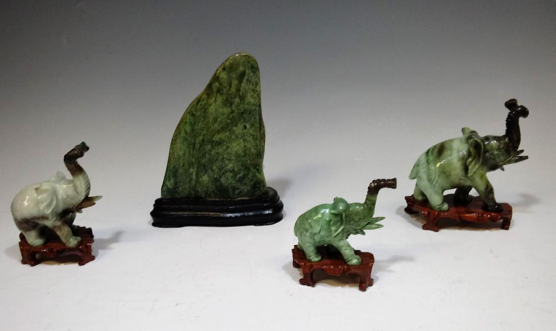 (4) Green Stone Elephants w/ Stands & Mountain: Set of three green stone elephants in varying sizes and a green stone carving in the form of a mountainside. The elephants are in varying sizes. Dimensions are: the tallest elephant is 3 3/8 inches ta