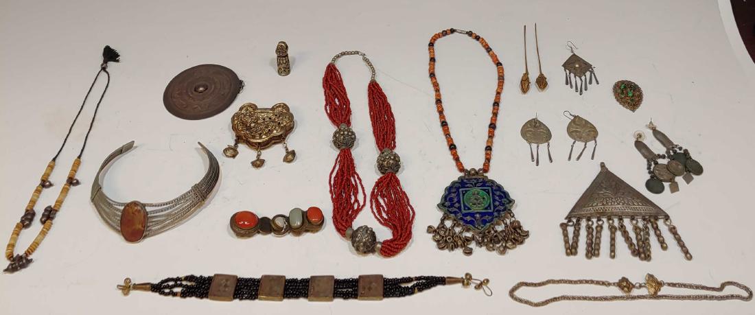 (18) Group of Indian and Other Jewelry: Five necklaces, two hairpins, two large pendants, two pair earrings, a decorative cap or finial, silver and shell necklace, a copper, carnelian and jadeite buckle and a clip with green tiger eyes, Som