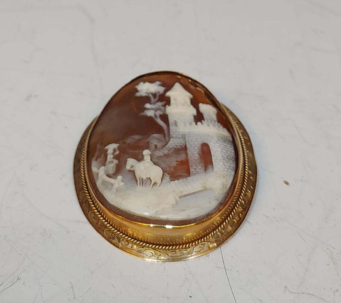 Antique Scenic Carved Shell Cameo Brooch: Carved Shell Cameo Brooch: The cameo carved with a scenic design of riders on horseback with a castle in the distance. Dimensions are: 2 inches tall X 1 3/4 inches wide. All measurements are approxima
