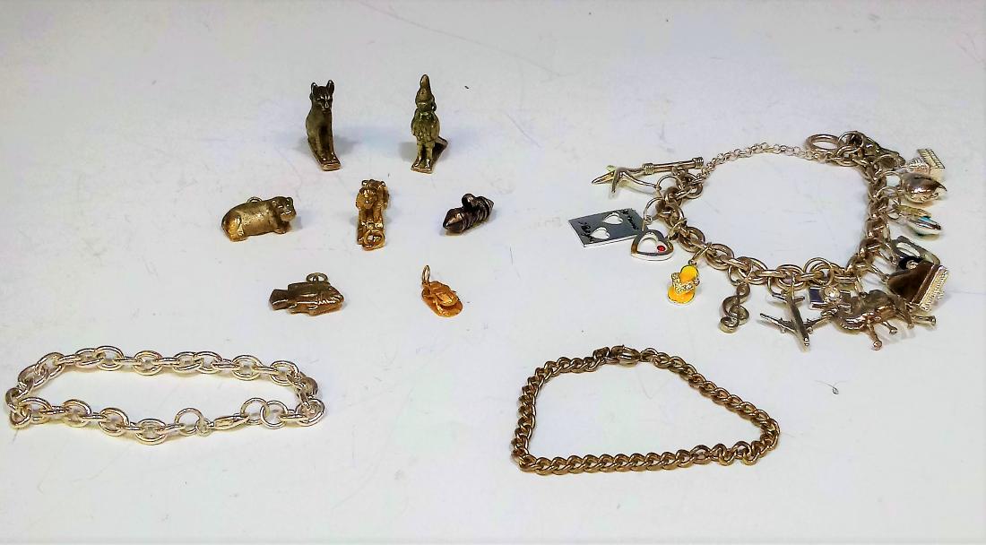 3 Charm Bracelets and 2 Extra Charms: 3 charm bracelets, one without charms attached, one with 16 charms, and the third with 5 unattached Egyptian charms from the Metropolitan Museum of Art, and one gold scarab charm and a carnelian bead 