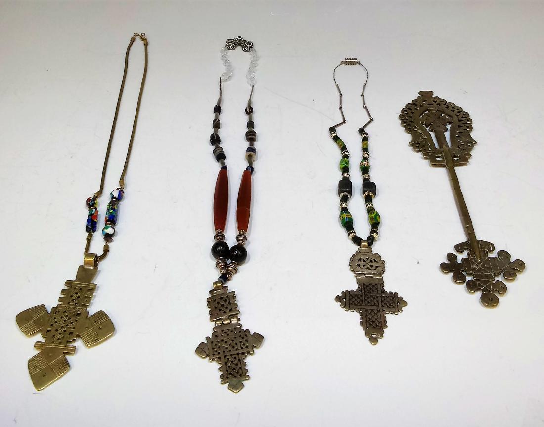 Group of 4 Metal Alloy Ethiopian Coptic Crosses: Group of 4 metal alloy Ethiopian coptic crosses, of which, 3 are made into necklaces with other glass, stone, metal, and resin beads. One of the cross necklaces appears to have been plated with a thin
