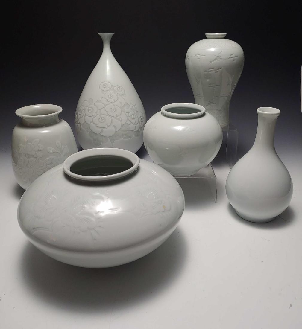 (6) White Incised Korean Porcelain Vases: Group of (6) white on white Korean vases: a) 2 plain white vases; b) 1 with raised floral pattern; c) 3 with incised floral or crane patterns. Each vase has a different 2-character mark and seal on ba