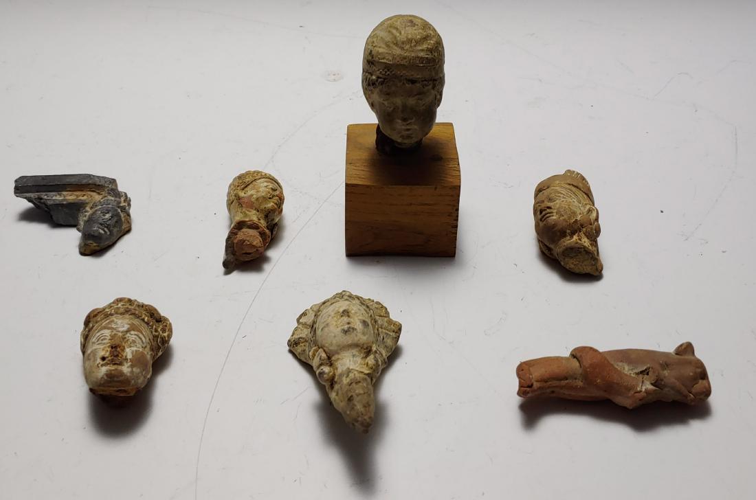 (7) Carved Earthenware & Stone Figures: Group of (7) small carved earthenware and stone figures, primarily head fragments but also one panther. One head fragment is mounted onto a square wooden base. European and/or Pre-Columbian. Dimension