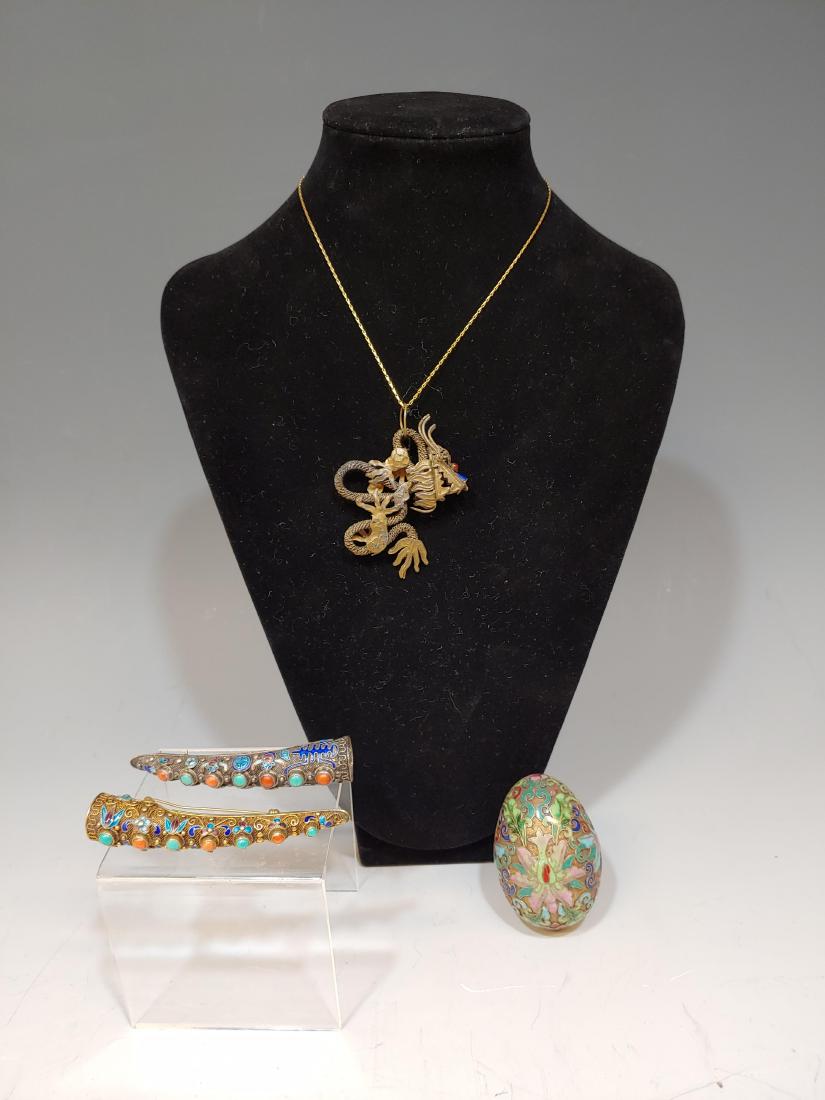 (4) Pieces Chinese Jewelry Plus: Two enameled silver fingernail sheaths with coral & turquoise, converted to brooches. A dragon pendant with enameled face and an enameled brass egg. Dimensions are: sheaths - 3 3/8 inches long X 5/8 i