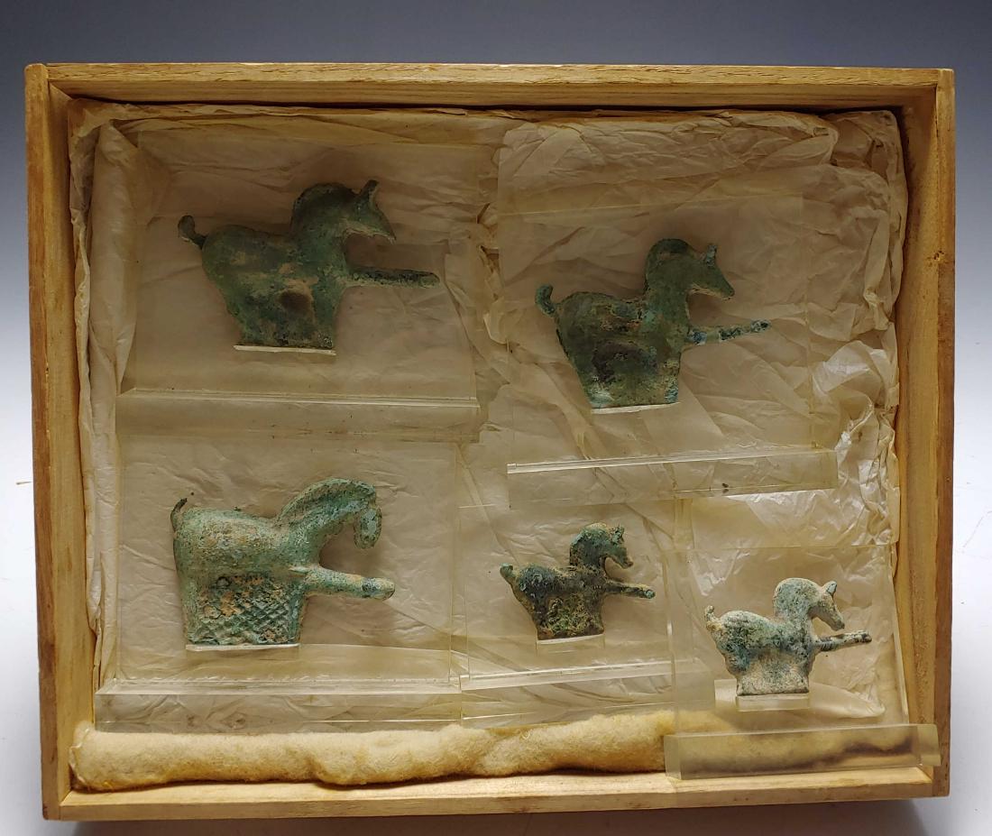 (5) Japanese Antique Bronze Horse Buckles: Set of five horse form buckles made of bronze mounted on acrylic stands. One horse has lattice decoration below the horse. Comes in a wooden box. Dimensions are: largest - buckle, 3 1/2 inches wide X