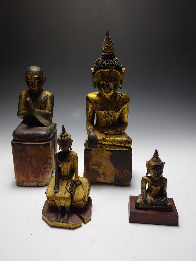 (4) Thai Carved and Giltwood Buddhas & Monk: Group of 4 carved wooden and giltwood Buddha and monk figures, Thai, 19th & 20th century. Two of the Buddhas are depicted in the bhumisparsha Buddha; while the third Buddha sits on a boulder with legs