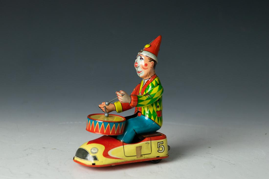 West German Windup Drumming Clown in Car: West German windup drumming clown in car, tin with rubber wheels. Made by NBN circa 1960. Mark on back of car says MADE IN WEST GERMANY. Dimensions are: 6 inches high X 4 1/2 inches long X 2 3/8 inche