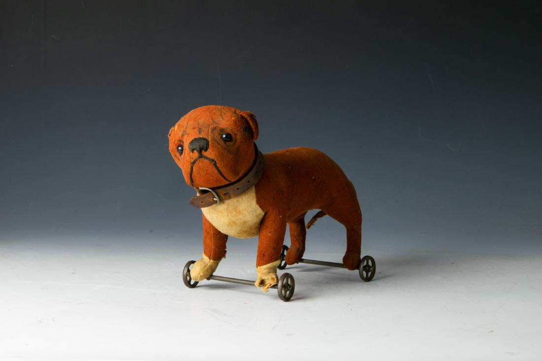 Early Steiff Bulldog "Tige" on Wheels Circa 1910: Early Steiff bulldog "Tige" on wheels, circa 1910. Felted fabric exterior over straw skeleton, leather collar, resin eyes. Dimensions are: 11 1/2 inches long X 5 1/8 inches wide X 8 inches high. All m