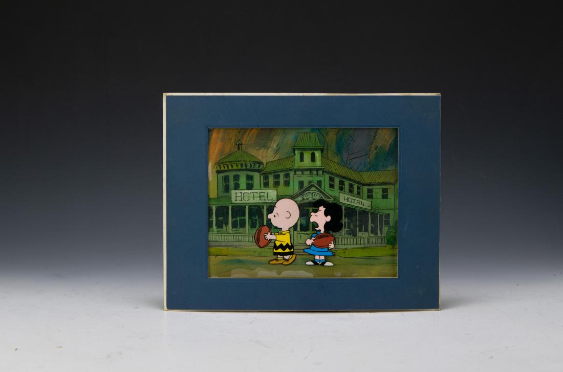 Peanuts Charlie Brown & Lucy Production Cel: Peanuts Charlie Brown & Lucy production cel housed in blue mat, dating from 1970s. Handwritten inscription on back of mat says Baycon San Francisco 1978 July 21-23. Dimensions are: sight size 9 1/2 in