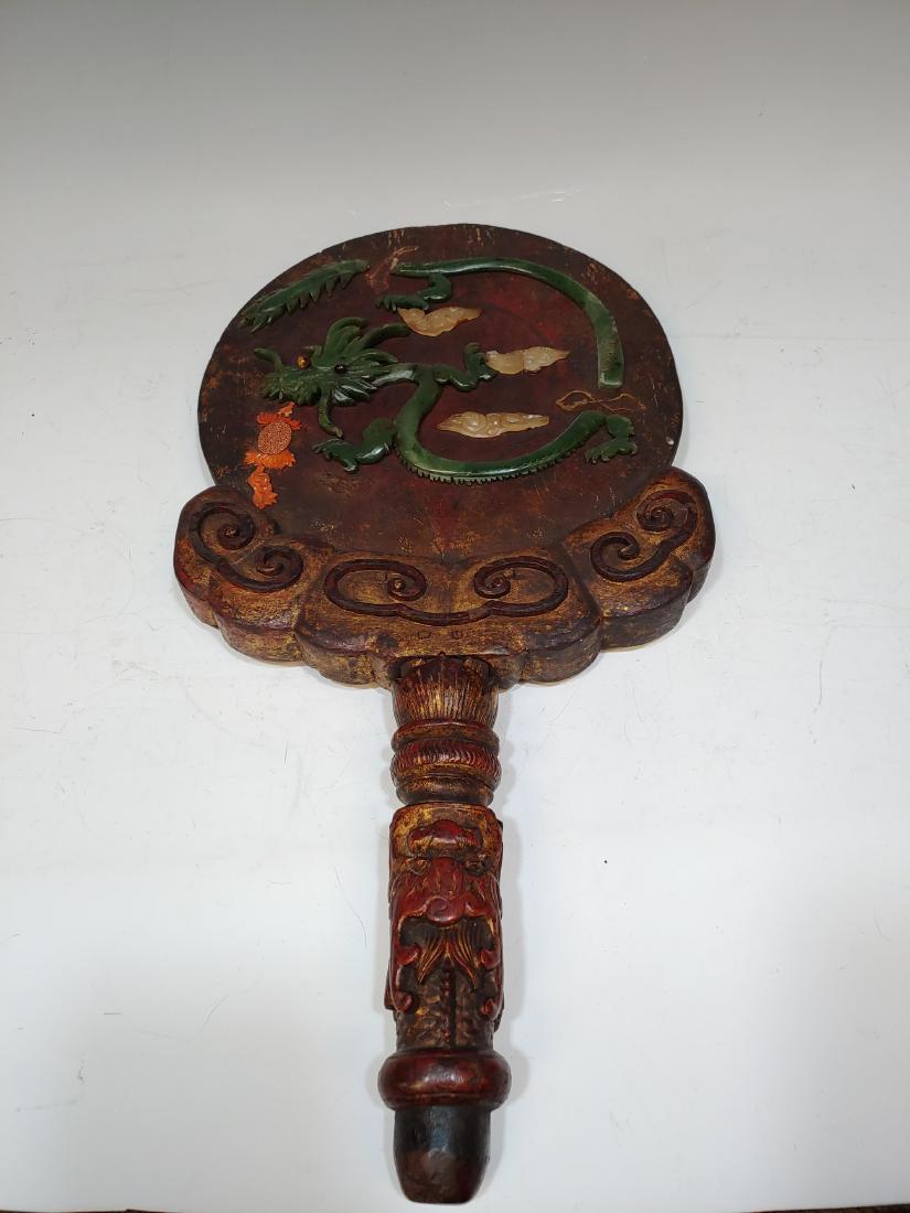 Wooden Mirror with Stone Dragon Detail: Chinese wooden mirror that has been reinterpreted as a wall hanging and features semi-precious stone pieces in the shape of a dragon. Stone includes: coral, goldstone, jade, tigers eye, and agate. Dim