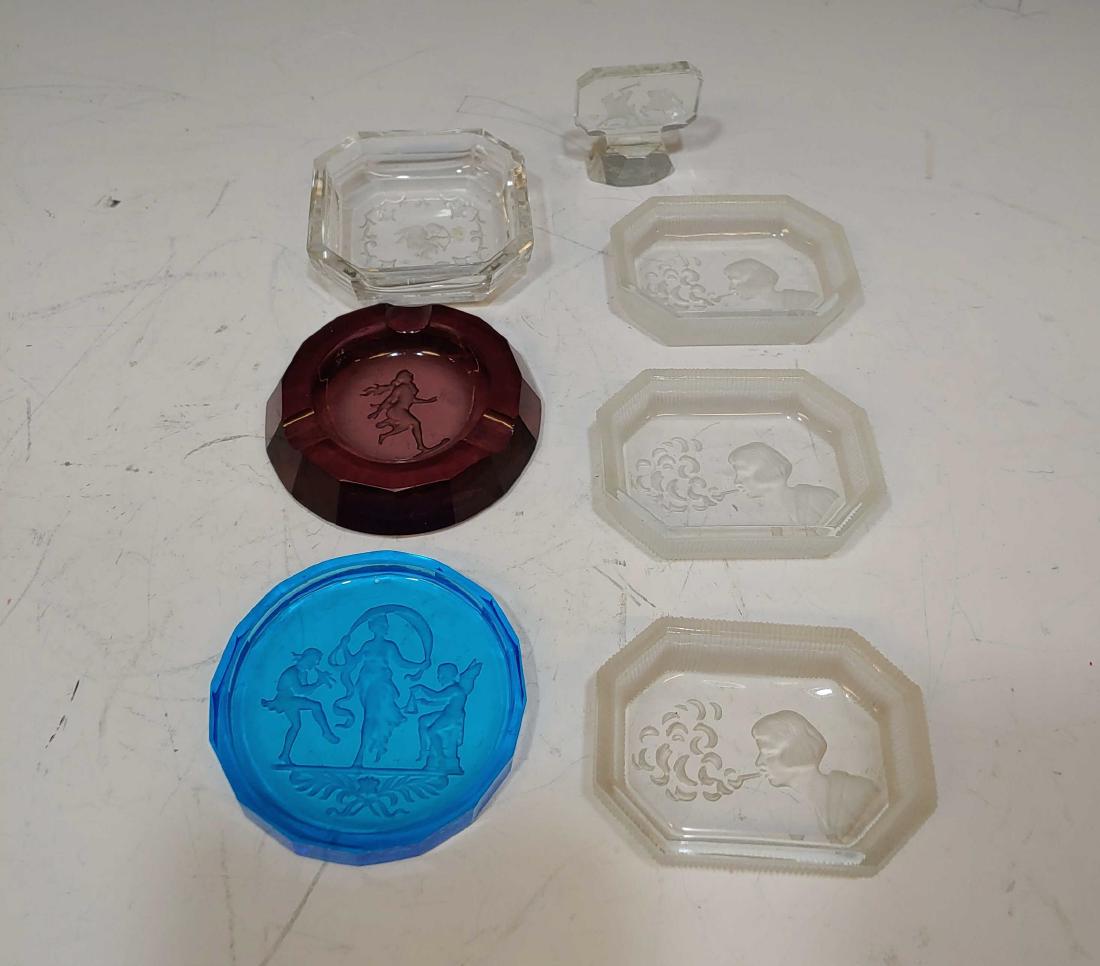 (7) 1920s Czech Glass Intaglio Trays, etc.: Amethyst ashtray, three clear & frosted open salts, blue coaster, small clear dish with cupid and a small paperweight. Dimensions are: largest 2 7/8 inches dia. All measurements are approximate. Condi