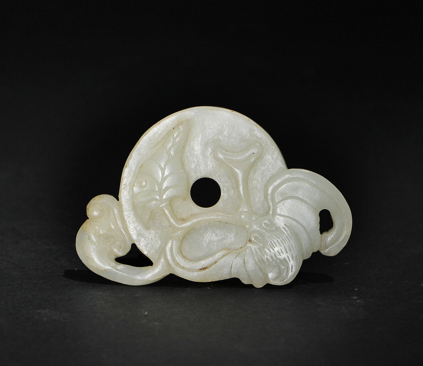 Chinese White Jade Bi Disc with Bat, 17-18th Century: A Chinese white jade bi disc dating from the 17th to the 18th century. The bi disc is carved on 1 side with a bat and lingzhi, and ruyi motifs and a diamond pattern on the other. Dimensions are: 1 3/4